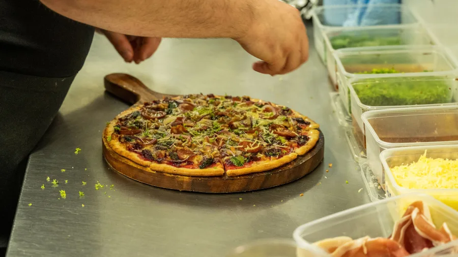 Chef preparing a fresh woodfired pizza at Sunshine Brewery Tap Room in Gisborne