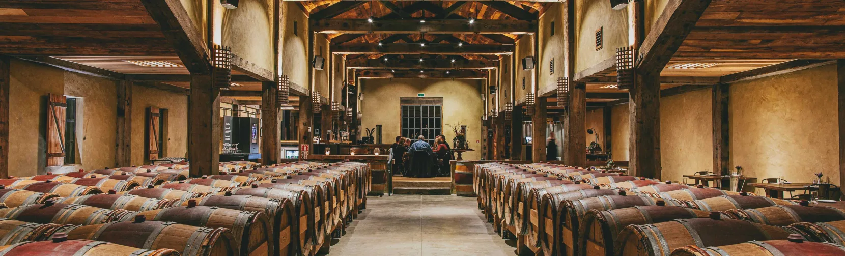 Barrel room at Church Road Winery with timber beams and rows of French oak barrels