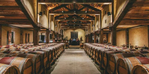 Barrel room at Church Road Winery with timber beams and rows of French oak barrels