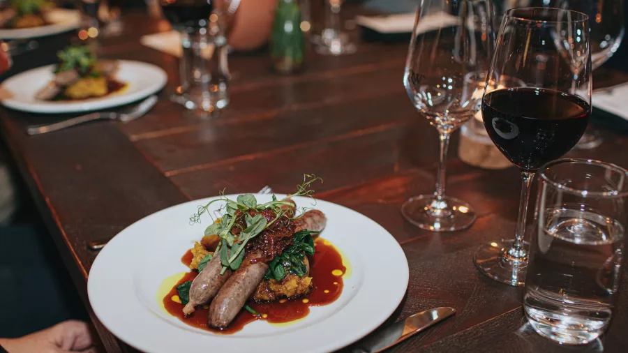 Plated gourmet dish with red wine during a fine dining experience at Church Road Winery