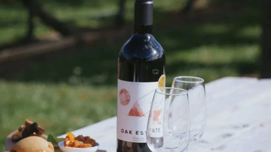 Wine and platter at Oak Estate Winery with vineyard in the background