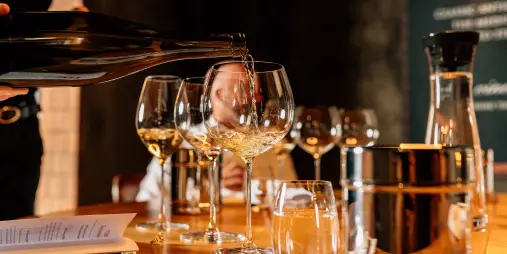 White wine being poured into glasses during a guided tasting at Church Road Winery in Hawke’s Bay