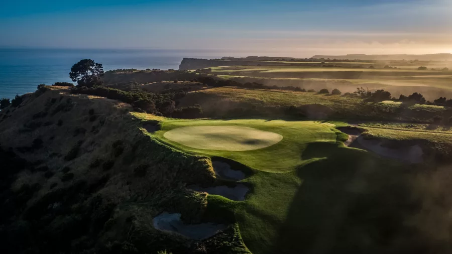 Golf hole at sunrise on Cape Kidnappers course with sweeping views near Napier