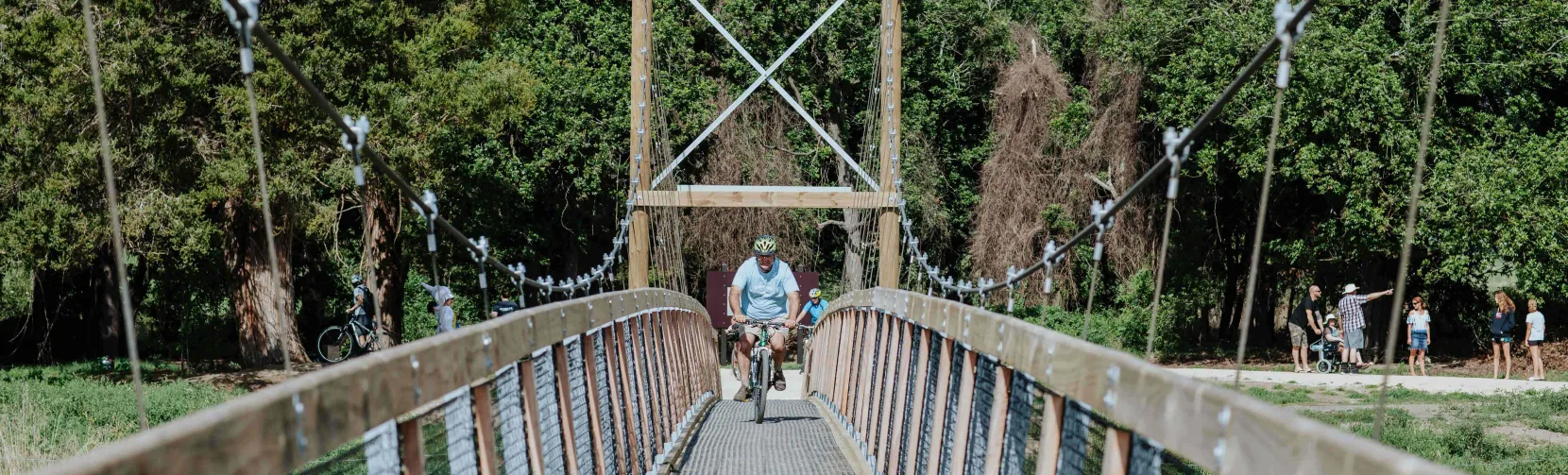 Cyclist crossing the Tuki Swing Bridge on the Tukituki Trails in Hawke’s Bay