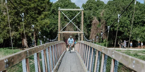 Cyclist crossing the Tuki Swing Bridge on the Tukituki Trails in Hawke’s Bay