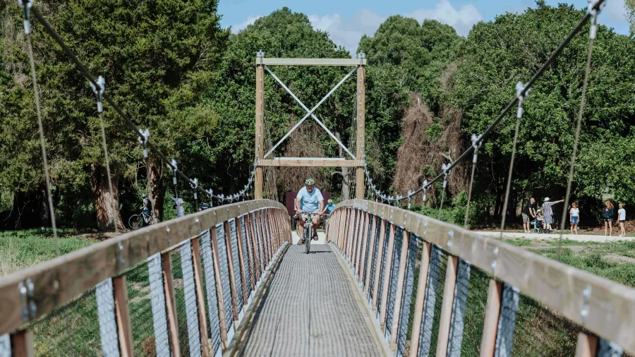Cyclist crossing the Tuki Swing Bridge on the Tukituki Trails in Hawke’s Bay