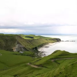 Scenic coastal view of Cape Kidnappers and winding road from the overland safari tour