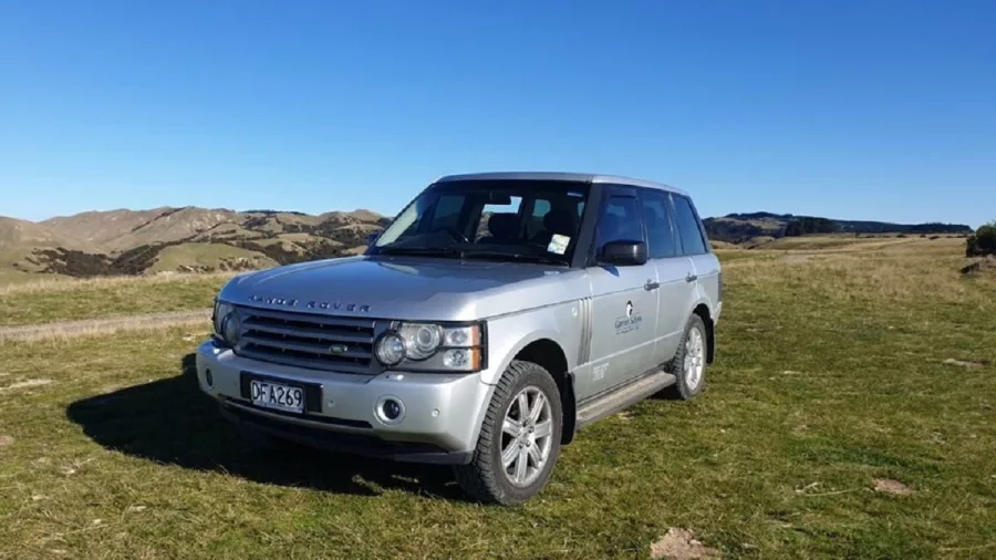 Gannet Safaris branded Range Rover parked on grassy hill during Cape Kidnappers private tour