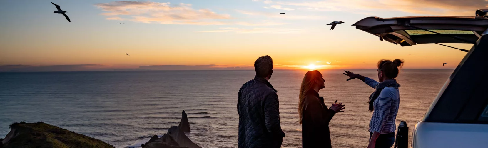 Tour group enjoying the sunrise view at Cape Kidnappers overlooking the Pacific Ocean
