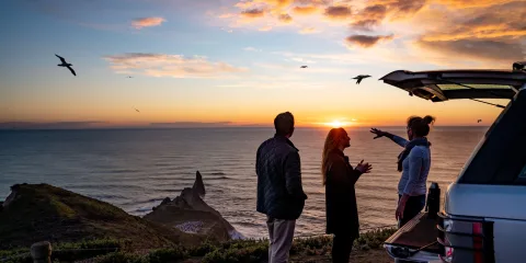 Tour group enjoying the sunrise view at Cape Kidnappers overlooking the Pacific Ocean
