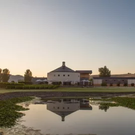 Sunset reflecting on the lake in front of Giant’s Winery with vineyard and mountain backdrop