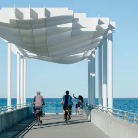 Cyclists riding along the Marine Parade viewing platform overlooking the ocean in Napier