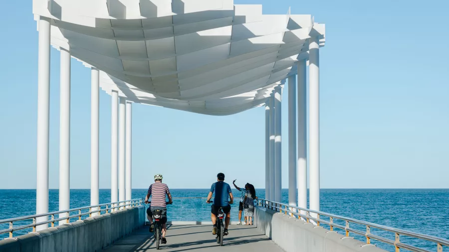 Cyclists riding along the Marine Parade viewing platform overlooking the ocean in Napier