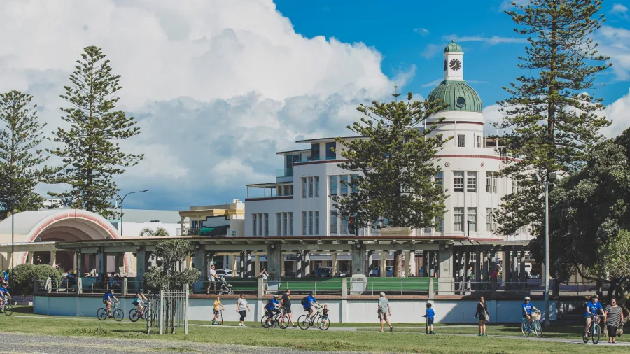 Cyclists riding along Marine Parade in front of Napier’s iconic art deco dome building