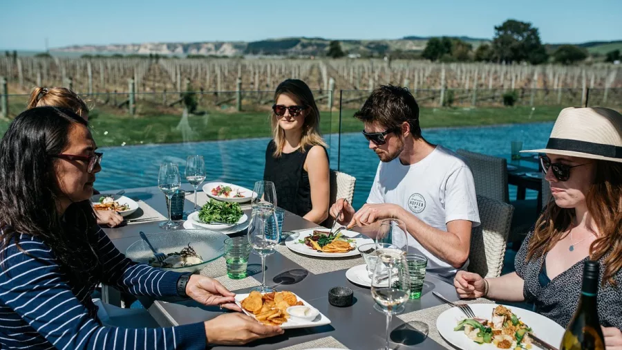 Group dining al fresco beside the vines at Craggy Range Winery in Hawke’s Bay
