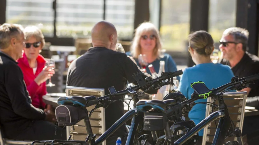 Cyclists enjoying lunch and wine at Clearview Estate Winery in Hawke’s Bay