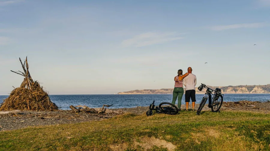 Cycling couple enjoying ocean views along the Hawke’s Bay coast