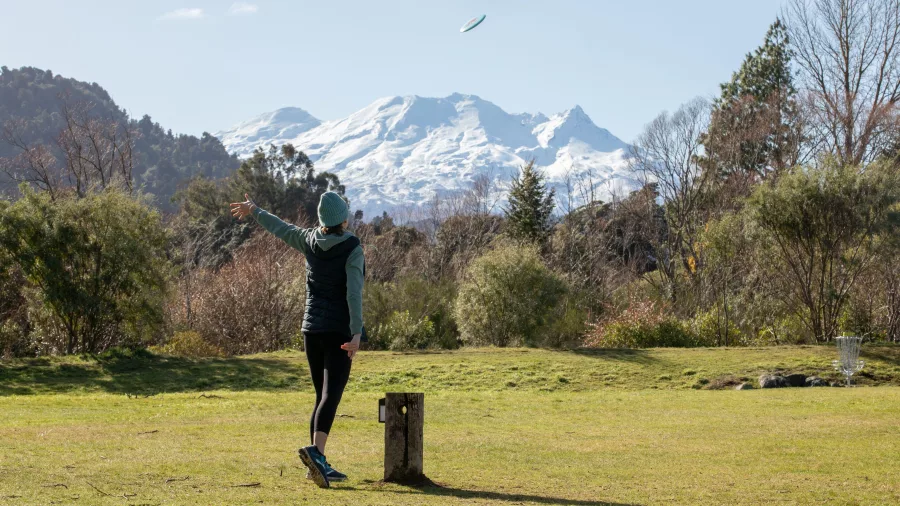 Woman playing disc golf in Ohakune with Mount Ruapehu behind
