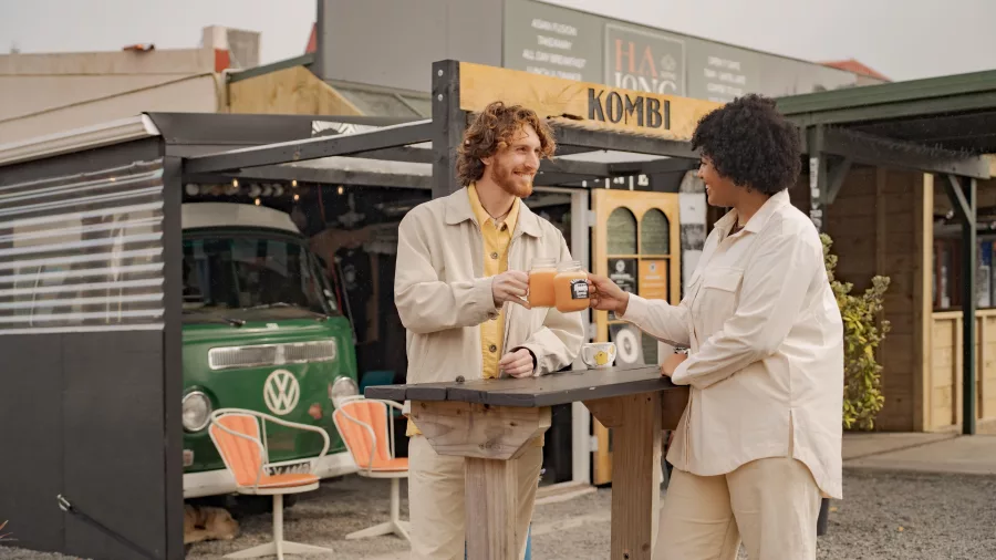 Couple enjoying drinks at Kombi café in Ohakune with a vintage VW van in the background