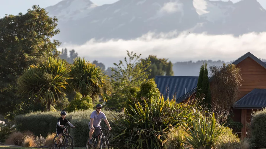 Father and son enjoying a quiet bike ride in Ohakune with Mount Ruapehu in the distance