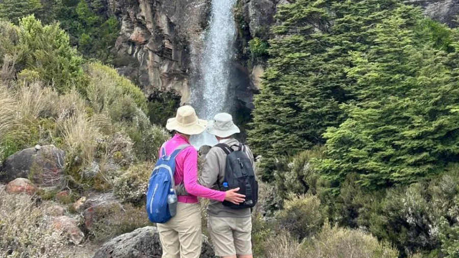 Couple admiring Taranaki Falls from the lower track in Tongariro National Park