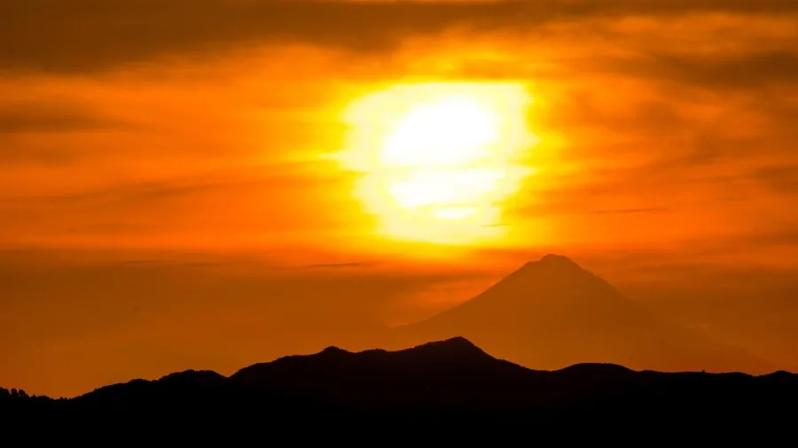 Golden sun setting behind Mount Ruapehu and surrounding peaks in Tongariro National Park