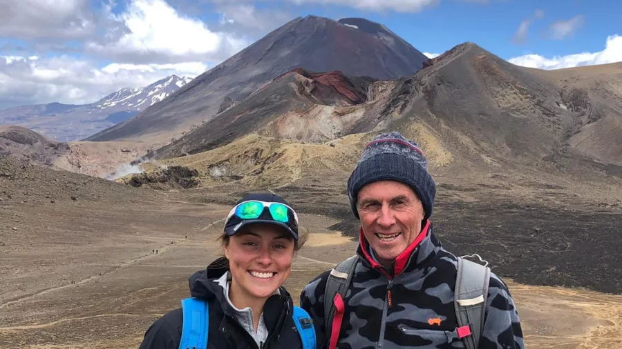 Smiling hikers with Mount Ngauruhoe in the distance