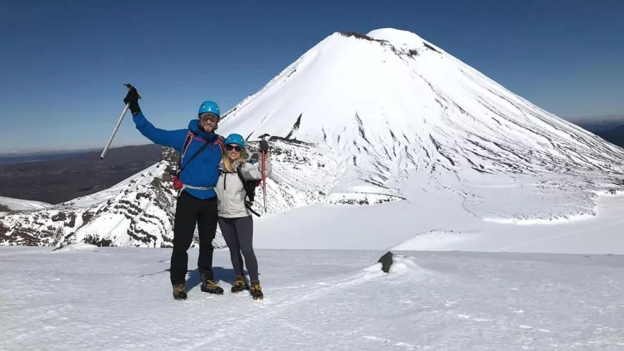 Couple on Tongariro Alpine Crossing in winter with Mount Ngauruhoe behind