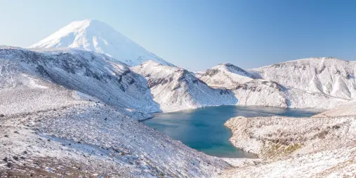 Upper Tama Lake surrounded by snow-covered volcanic peaks in Tongariro National Park