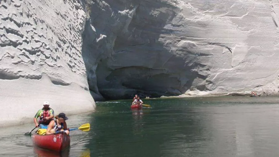 Canoeists paddling below towering white limestone cliffs on the Rangitikei River