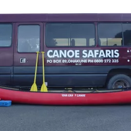 Canoe Safaris shuttle bus and red canoe parked roadside ready for Whanganui River adventure