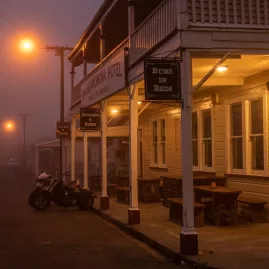 The historic Whangamōmona Hotel glowing in misty evening light on the Forgotten World Adventures route.