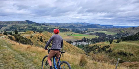 Man on an E-bike overlooking the Rangitikei River valley from a high viewpoint