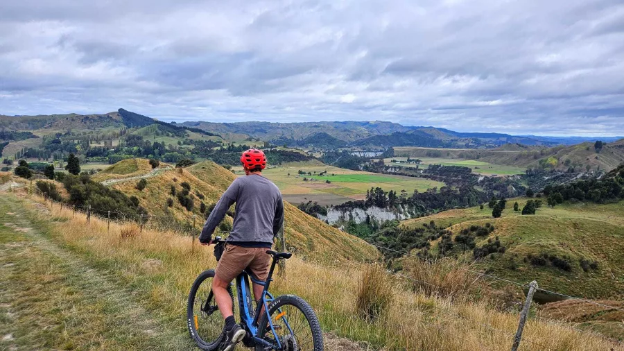 Man on an E-bike overlooking the Rangitikei River valley from a high viewpoint