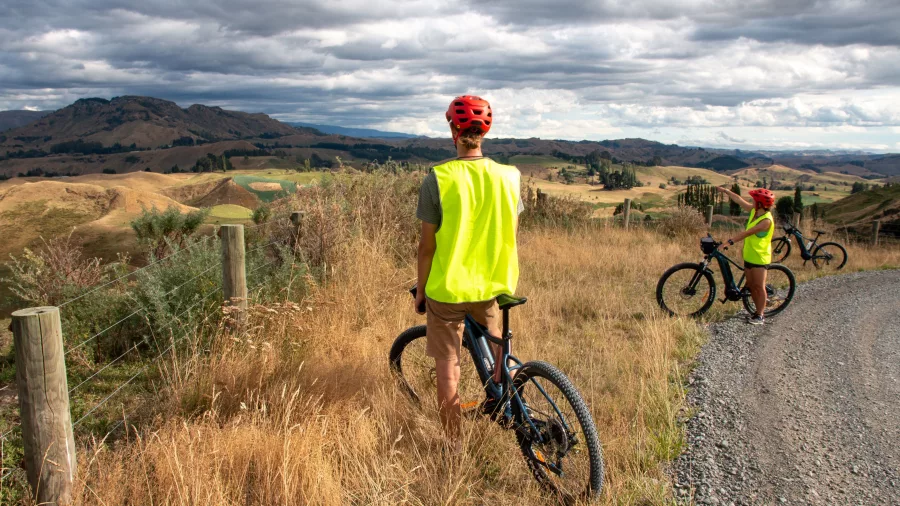 Two cyclists pause to take in the sweeping views of the Rangitikei Valley from a rural trail