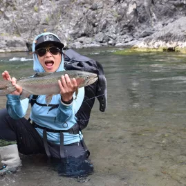 Excited angler holding up a freshly caught trout in the Rangitikei River