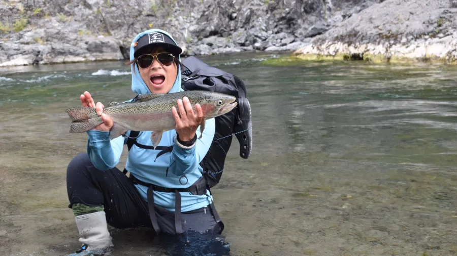Excited angler holding up a freshly caught trout in the Rangitikei River