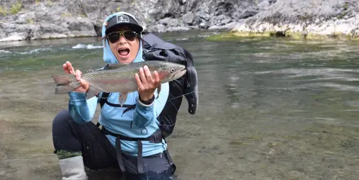Excited angler holding up a freshly caught trout in the Rangitikei River