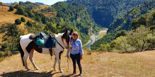 Rider standing with their horse at a lookout point above the Rangitikei River canyon