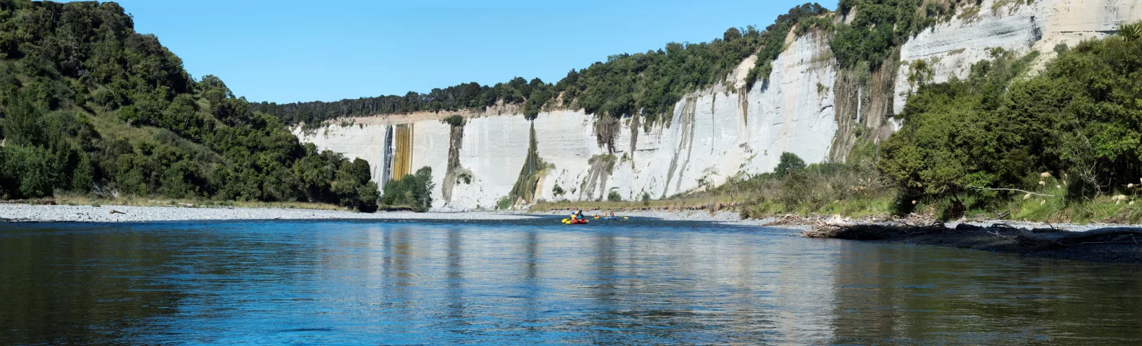 Rafting group approaching towering white cliffs along the Rangitikei River