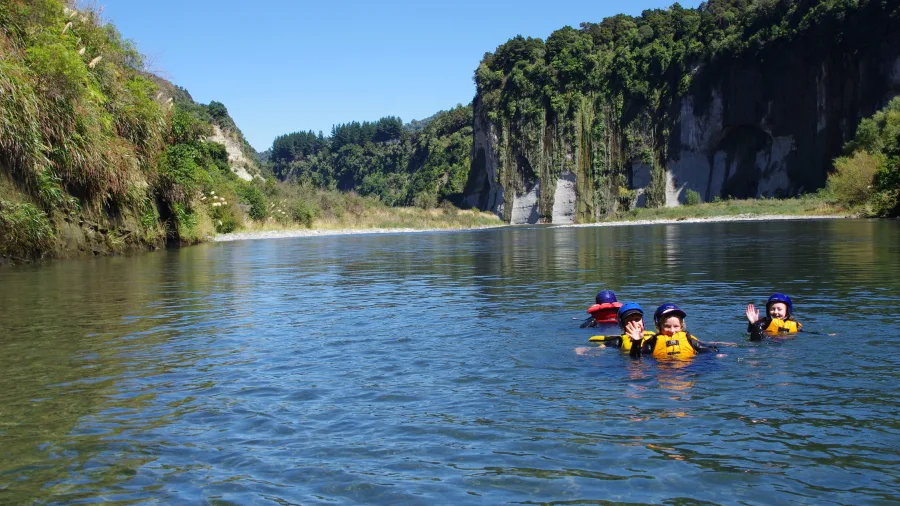 Kids swimming in the clear waters of the Rangitikei River under sunny skies