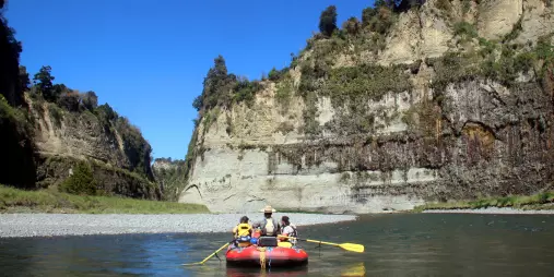 Group rafting through a wide scenic section of the Rangitikei River