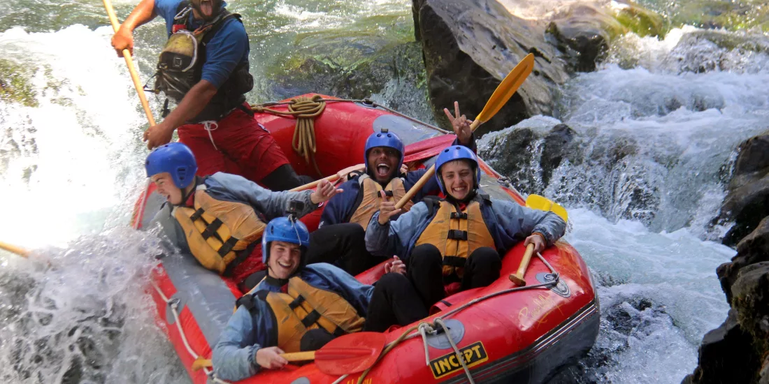 Excited rafting group dropping into a rapid on the Rangitikei River in New Zealand