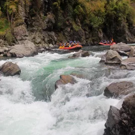 Rafters approach the See Thru rapid on the Rangitikei River, a Grade 5 white water challenge framed by boulders and swift currents