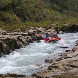 Rafters enter the tight Pinball Canyon rapid on the Rangitikei River, navigating narrow rock walls and fast-flowing whitewater
