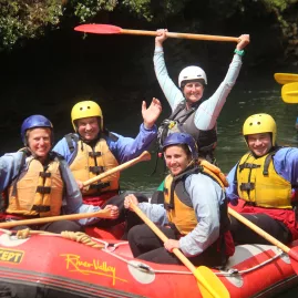 Happy rafting group posing with paddles after white water adventure on the Rangitikei River