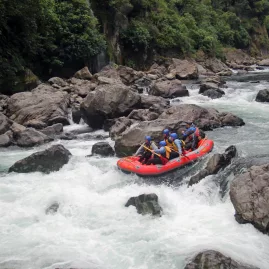 Raft navigating between large boulders on the Rangitikei River white water section