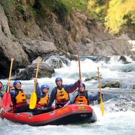 Rafting team celebrating with raised paddles after completing a series of rapids on the Rangitikei River