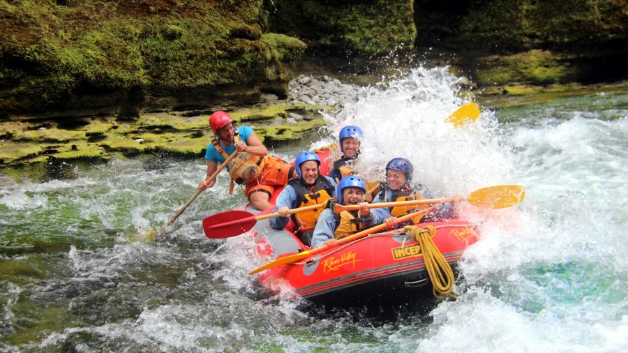 Rafters surf a standing wave in The Narrows on the Rangitikei River, surrounded by steep gorge walls