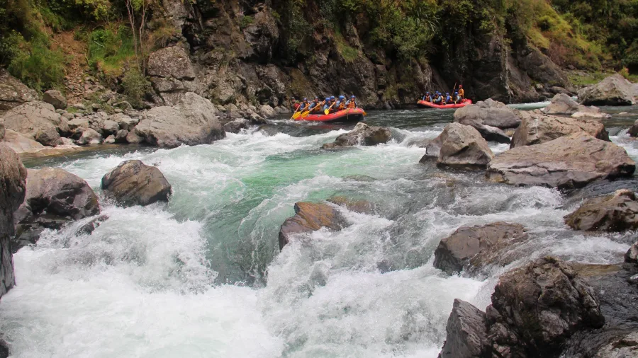 Rafters approach the See Thru rapid on the Rangitikei River, a Grade 5 white water challenge framed by boulders and swift currents